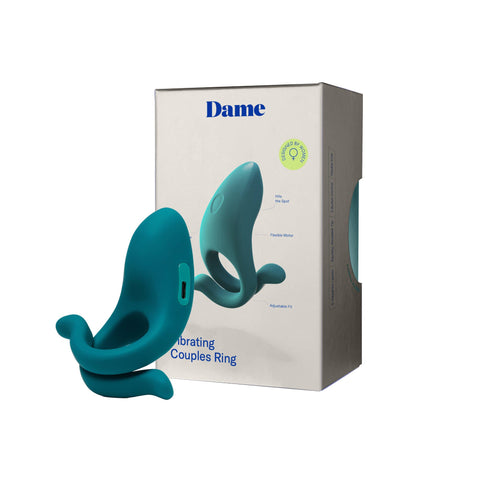 Teal vibrating couples ring with packaging labeled 'Dame' on a white background