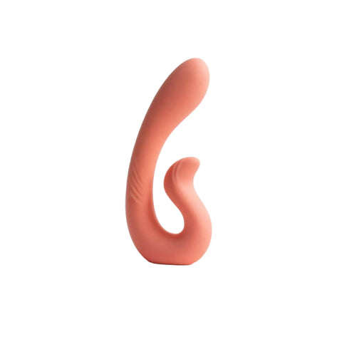 A curved, silicone personal massager in a muted peach-pink color, standing upright on a clean white surface against a white background.