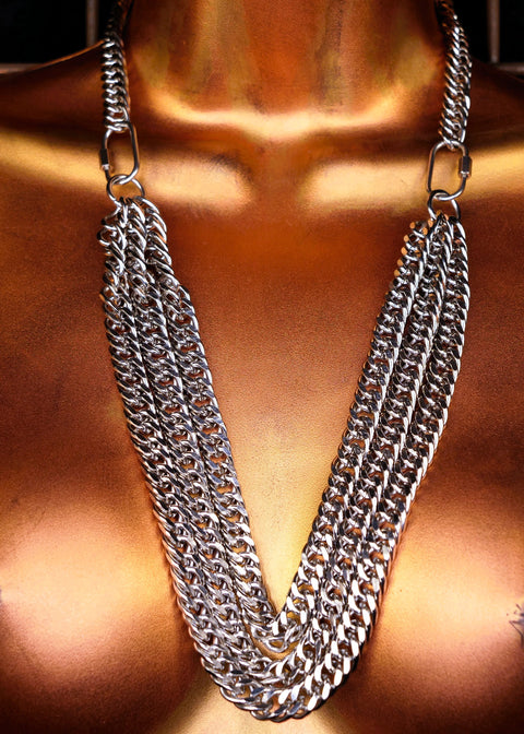 Mannequin wearing a silver chain necklace against a dark background