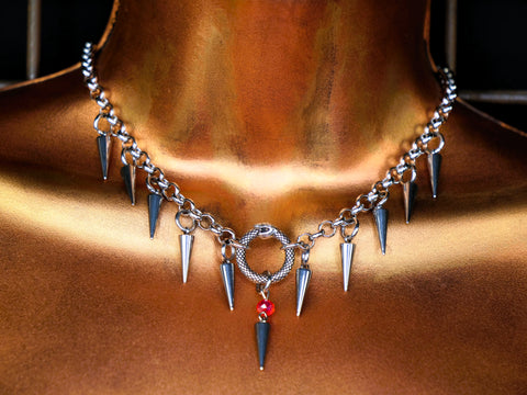 Necklace with spikes and a circular  snake pendant on a mannequin.
