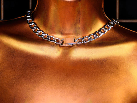 Silver chain necklace on a bronze surface