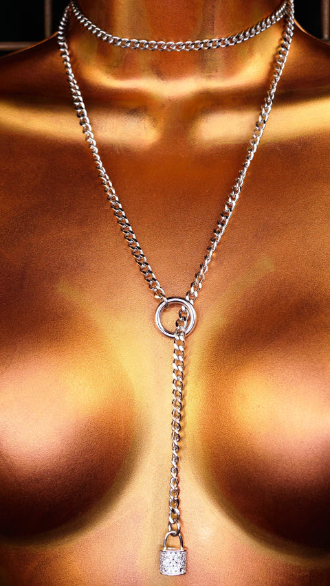 Mannequin torso with a slip chain necklace featuring a padlock pendant against a tiled wall background