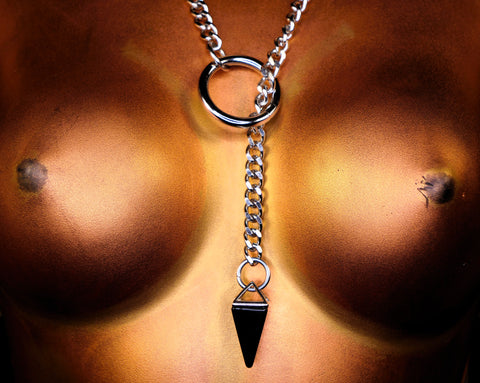 Necklace with a black pyramid pendant on a blurred background